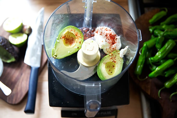 A food processor filled with avocados, yogurt, and peppers.