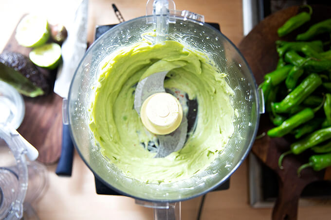 A food processor filled with puréed avocado cream.
