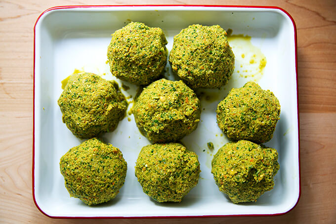 Falafel burger mix, portioned, balled, and on a tray.