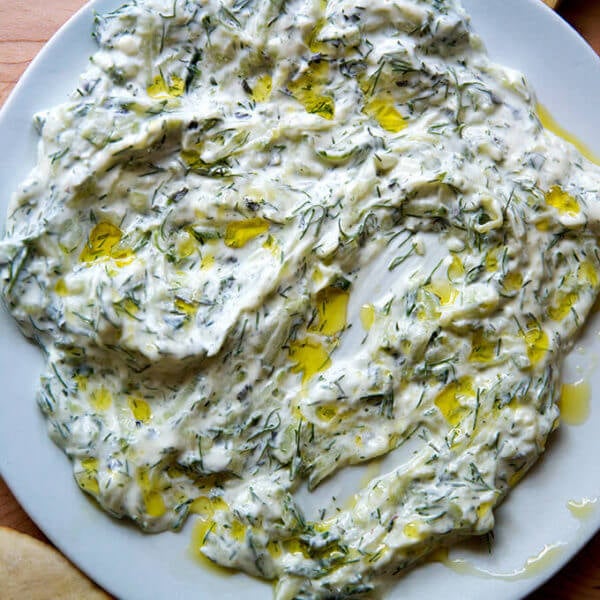 A platter of tzatziki, drizzled with olive oil aside pita.