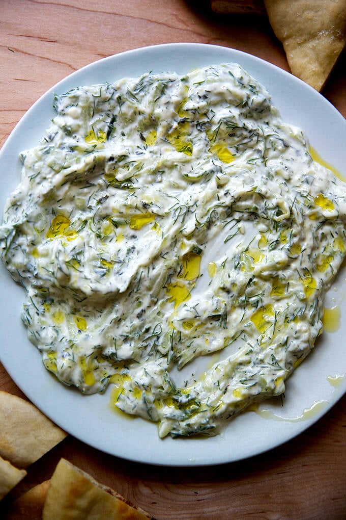 A platter of tzatziki, drizzled with olive oil aside pita.