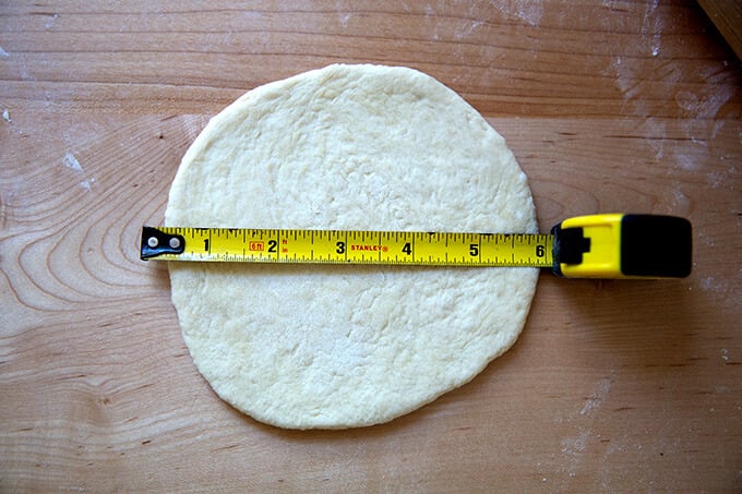 A round of uncooked pita bread measuring 6 inches in length.