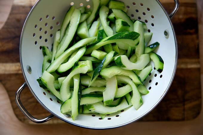 Drained cucumbers in a colander.