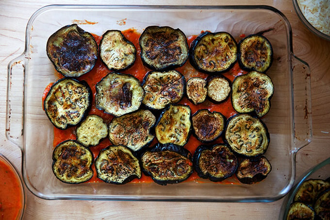 A 9x13-inch pan with a layer of sauce and roasted eggplant.