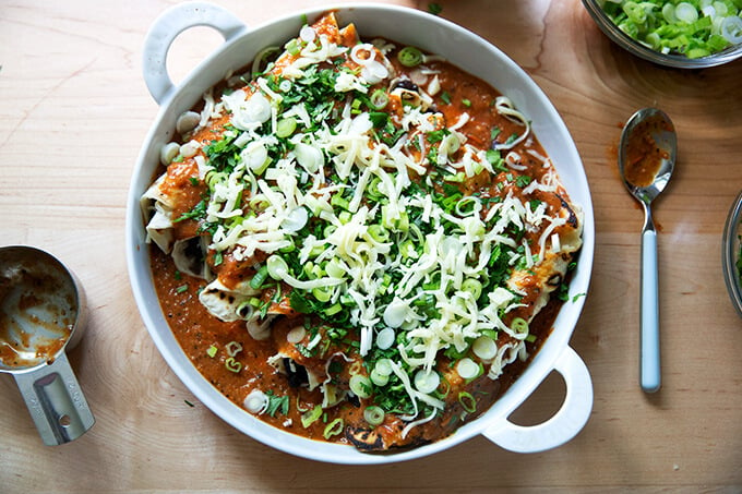 A baking dish filled with black bean and cheese enchiladas, ready for the oven.