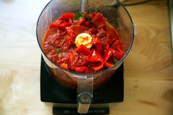 A food processor filled with tomato-basil sauce.