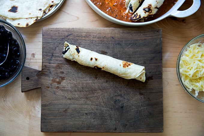 A single rolled flour tortilla filled with black beans and Monterey Jack cheese.