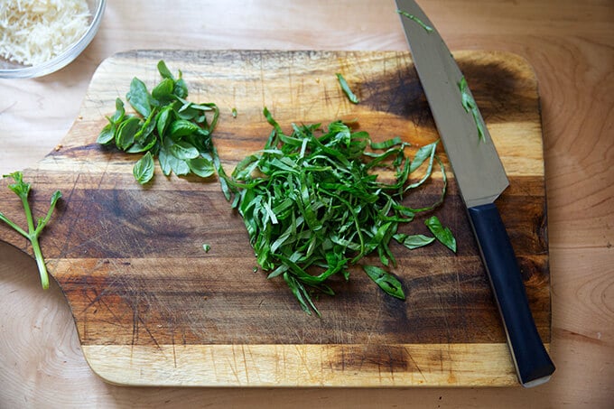 Fresh basil on a board, thinly sliced.