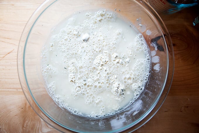 A bowl of ingredients to make thyme dinner rolls, unmixed.