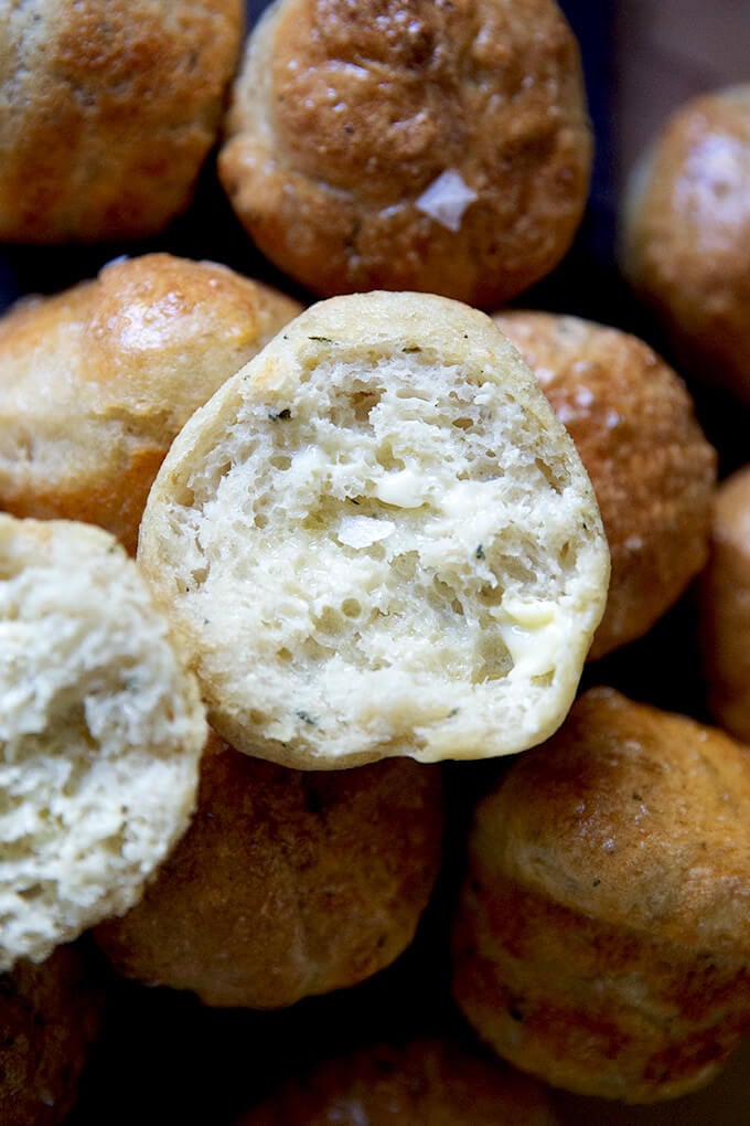 A halved and buttered thyme dinner roll.