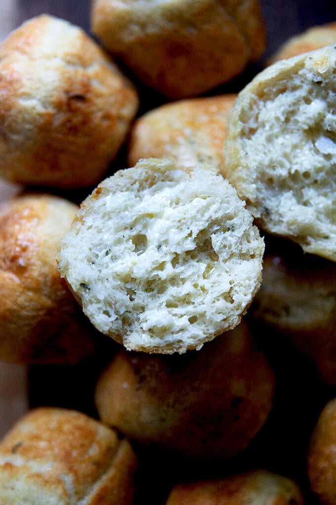 A halved and buttered thyme dinner roll.