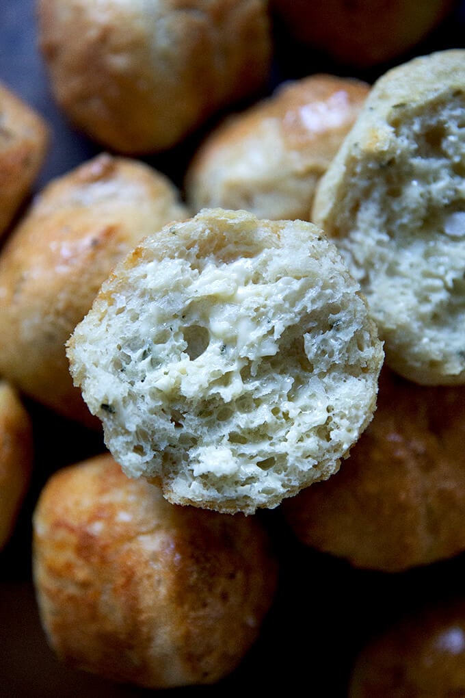 A halved and buttered thyme dinner roll.