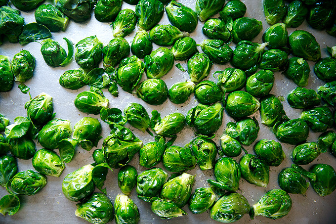 A sheet pan of Brussels sprouts ready to be roasted.