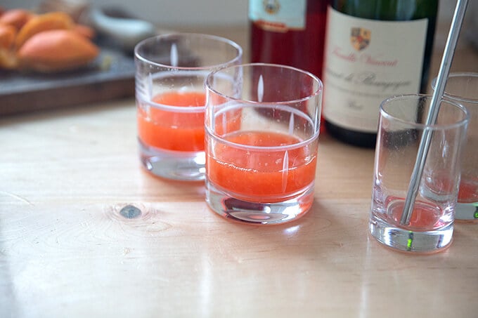 Two glasses filled with tangerine juice and Campari.