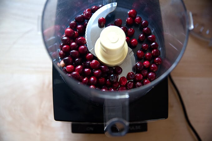 A food processor filled with cranberries.