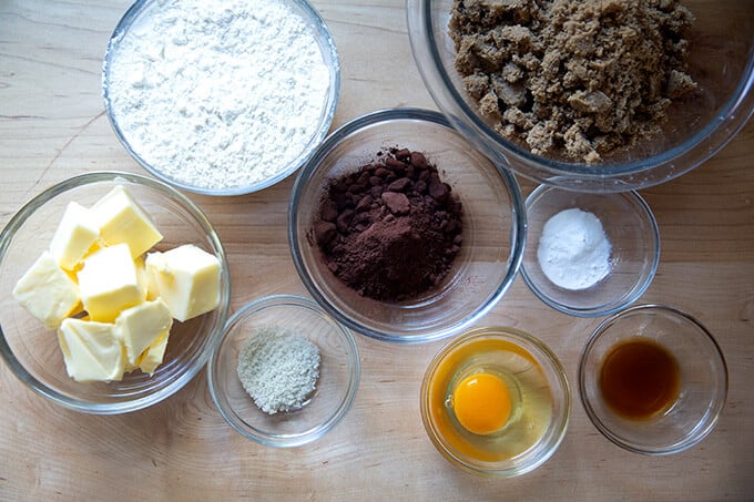 Ingredients to make chocolate sugar cookies on a work surface.