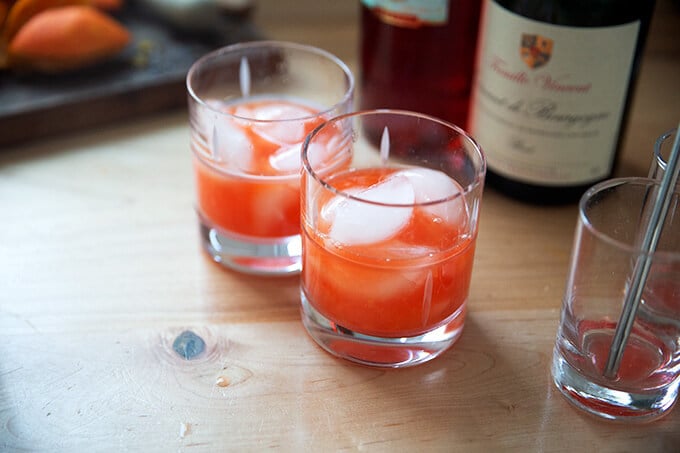 Two glasses filled with ice, fresh squeezed tangerine juice, and Campari.