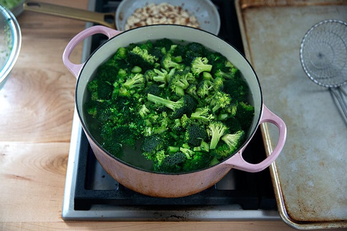 A large pot of boiling water filled with broccoli.
