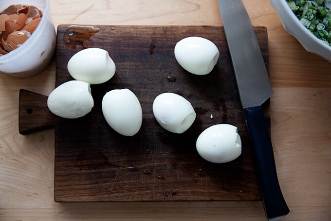 Six steamed hard boiled eggs on a board.