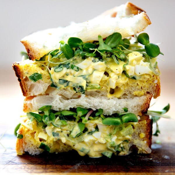 The best egg salad sandwich on a board.