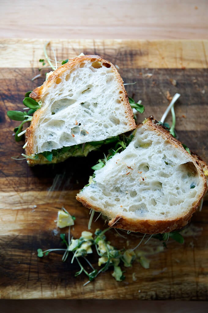 The best egg salad sandwich on a board.