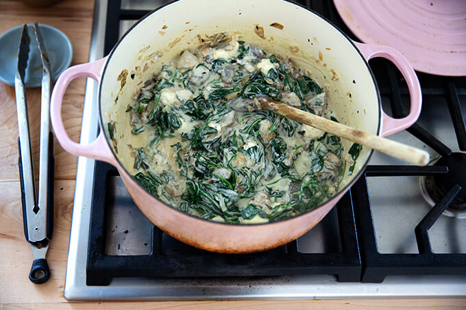 A large pot filled with just-mixed spinach-artichoke dip.