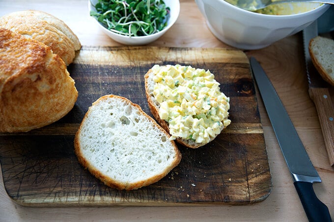 A halved egg salad sandwich on peasant bread.