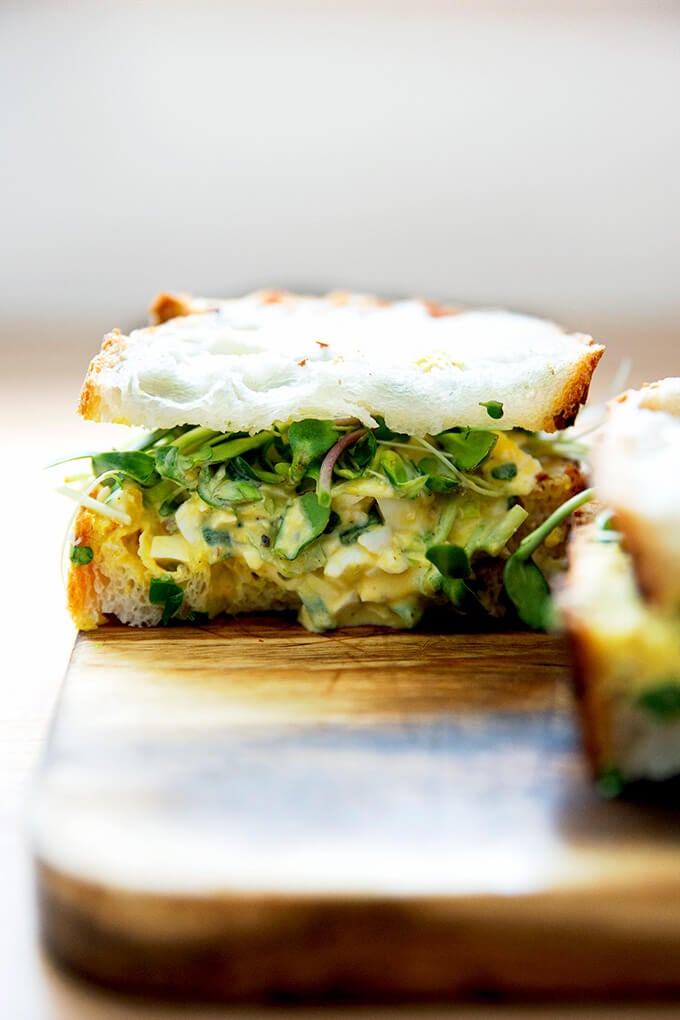 The best egg salad sandwich on a board.