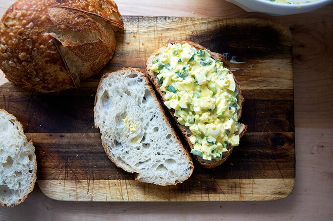 A halved egg salad sandwich on sourdough bread.