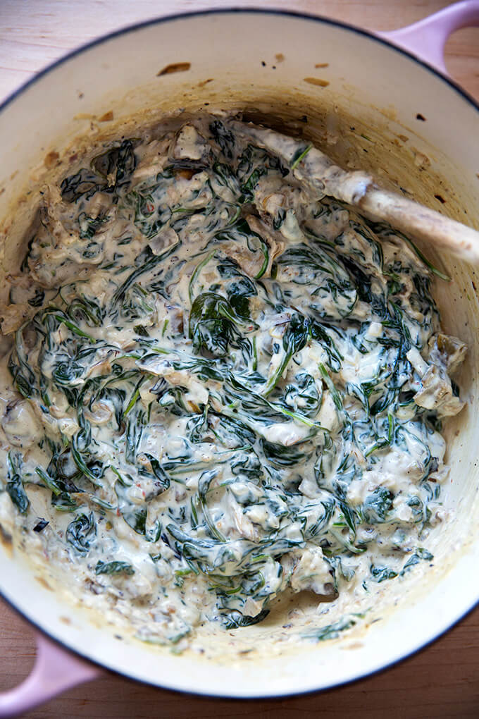 A large pot filled with spinach artichoke dip.