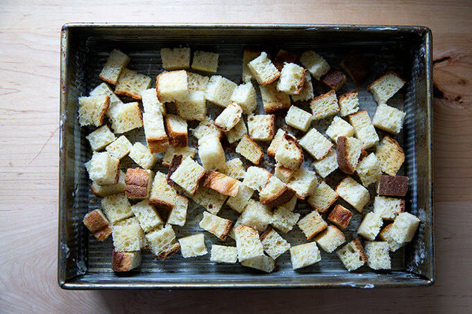 Cubes of toasted brioche in a 9x13-inch baking pan.