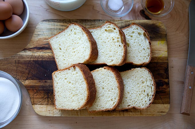 Six slices of brioche on a cutting board.