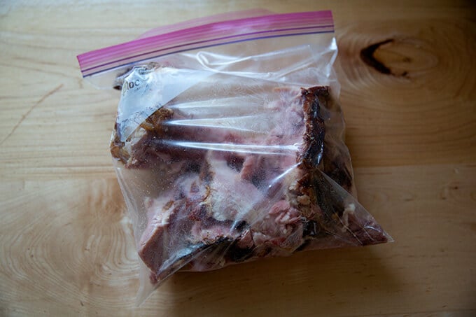 A ham bone in a ziplock bag on a countertop.