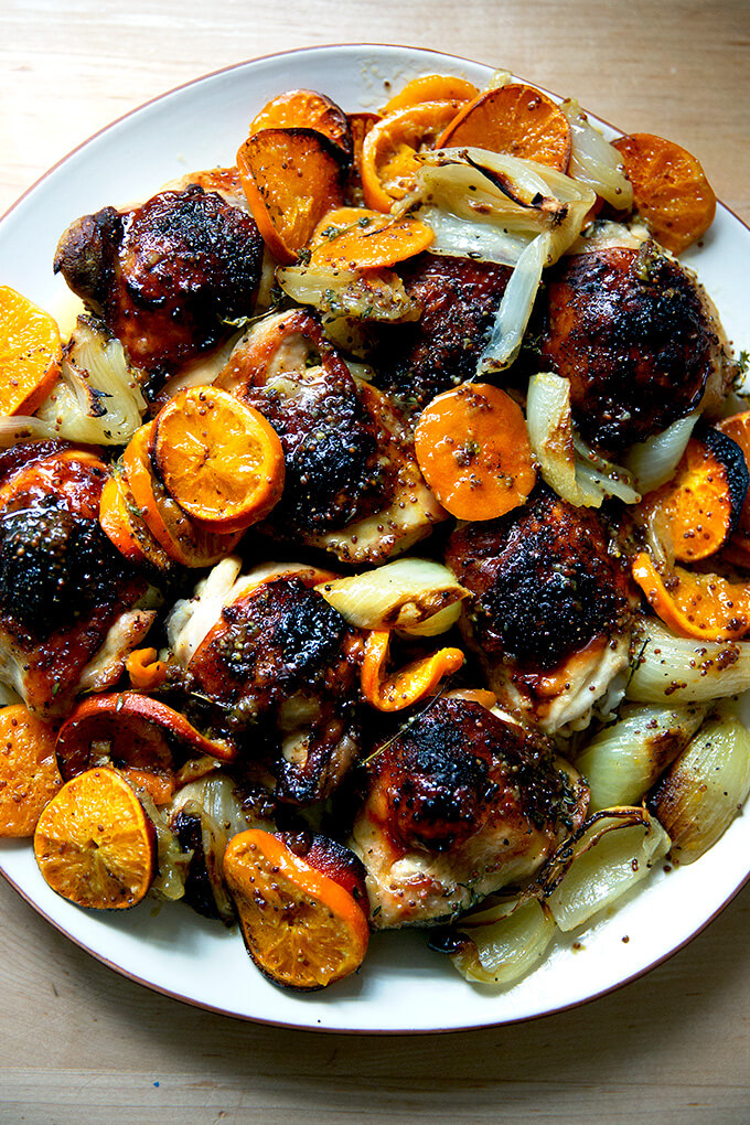 A platter of roast chicken and clementines. 