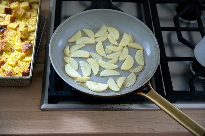 A skillet filled with sliced apples and butter.