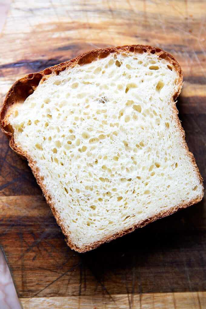 A slice of brioche bread on a cutting board.