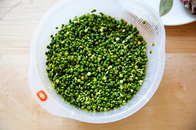 A collander holding rinsed green split peas.