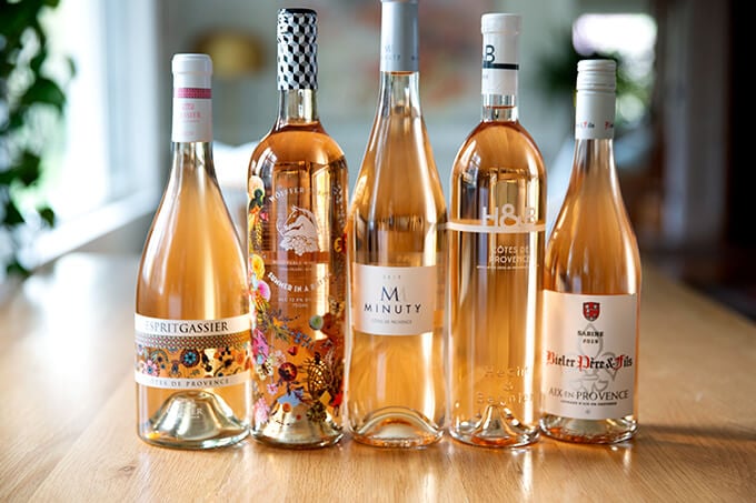 Five bottles of rosé on a table.