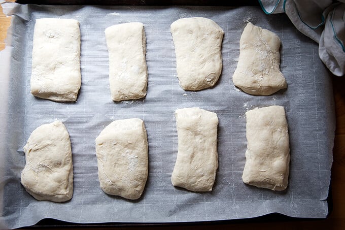 Cut ciabatta rolls, unbaked, on a sheet pan.
