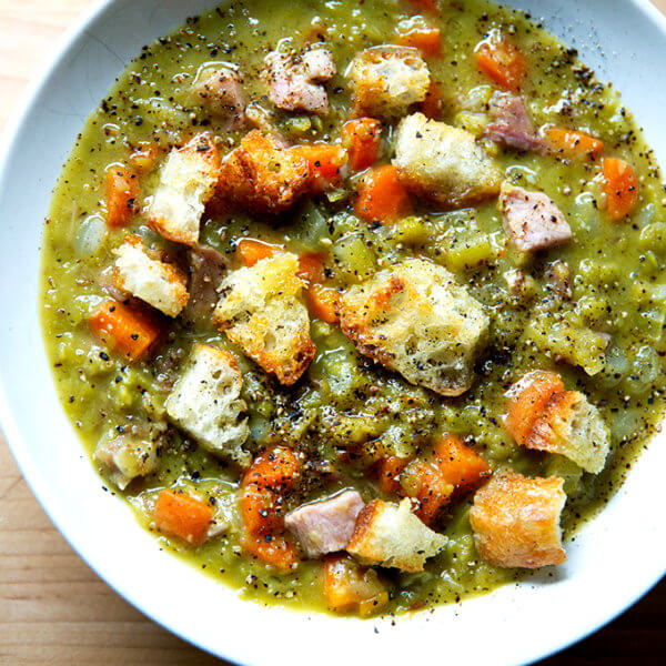 A bowl of split pea and ham soup topped with olive oil croutons.