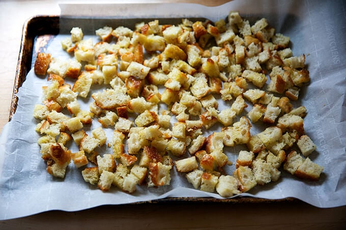 Untoasted croutons on a sheet pan.