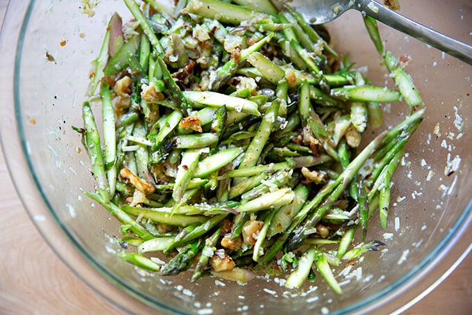 A bowl of raw asparagus salad all tossed together.