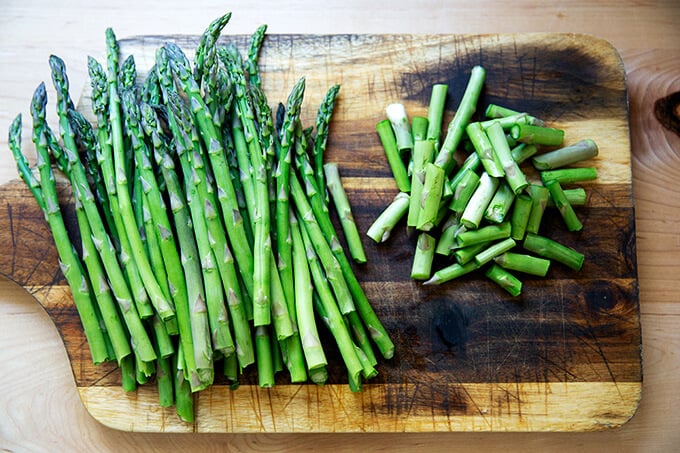 Asparagus, on a board, ends snapped off.