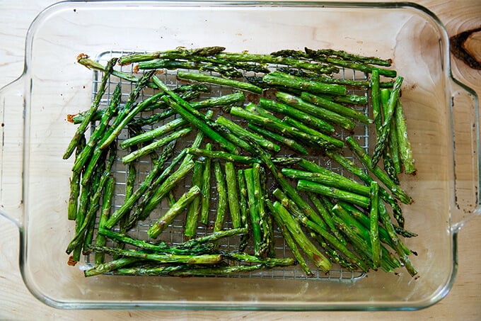 Roasted asparagus in a 9x13-inch glass baking dish.