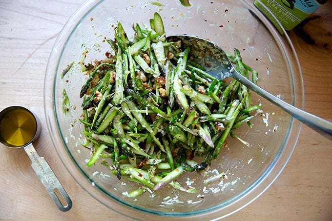 A bowl of raw asparagus salad all tossed together.