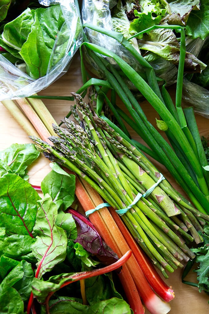A variety of spring produce: asparagus, rhubarb, Swiss chard, scallions, lettuce, and spinach.