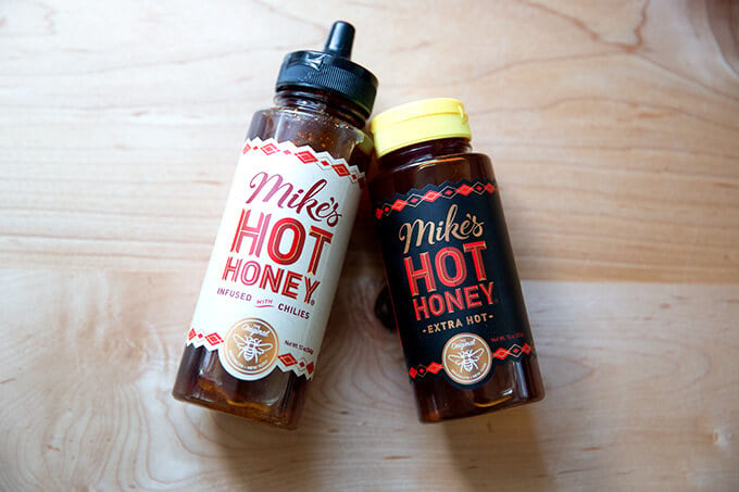 Two bottles of Mike's Hot Honey on a counter top.