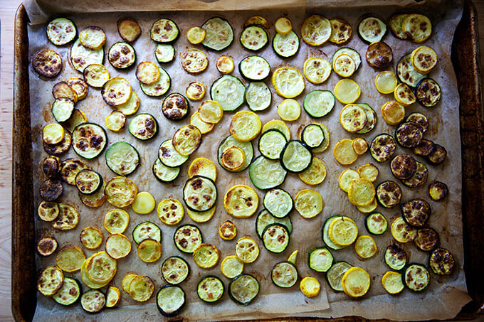 Roasted zucchini parmesan on a large sheet pan.