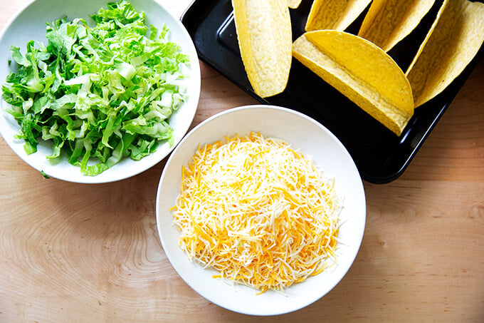 Grated cheese and lettuce in a bowl.