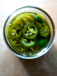 An overhead shot of a jar of pickled jalapeños.
